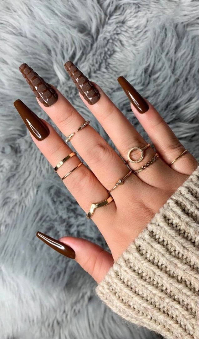 Chocolate swirl coffin nails with glossy brown marble swirls, gold rings and a grey fur backdrop
