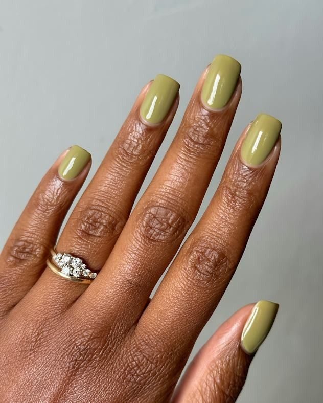 Olive green square nails on brown skin with a glossy sage olive gel and a diamond ring