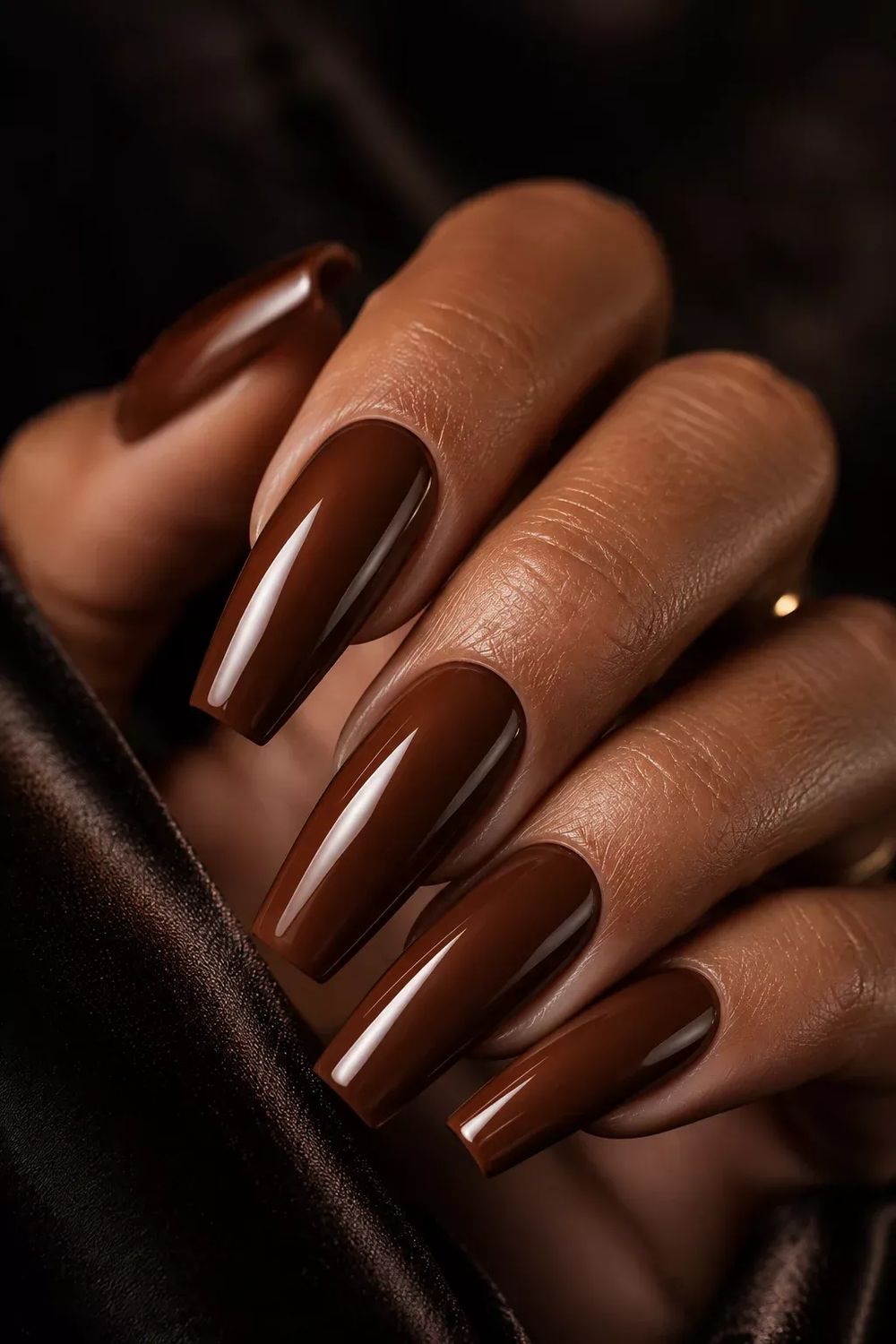 Chocolate coffin nails on brown skin, long glossy milk chocolate gel on a dark satin background