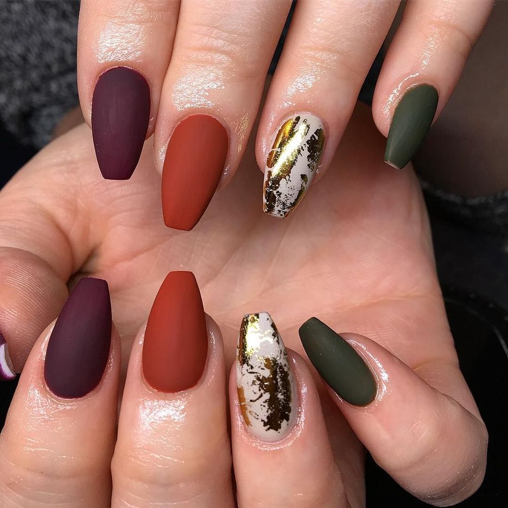 Matte autumn mix nails in plum, rust and olive on coffin nails with one gold foil accent nail